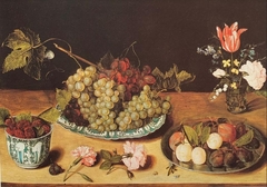Glass of flowers, plate with grapes, plate with plums and crow cup of black raspberries