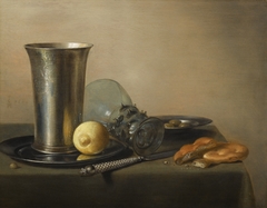 Still life with a silver chalice, lemon, bread, and berkemeyer by Pieter Claesz