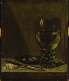 Still life with rummer, tin plate with olives, a knife and bread, on a table